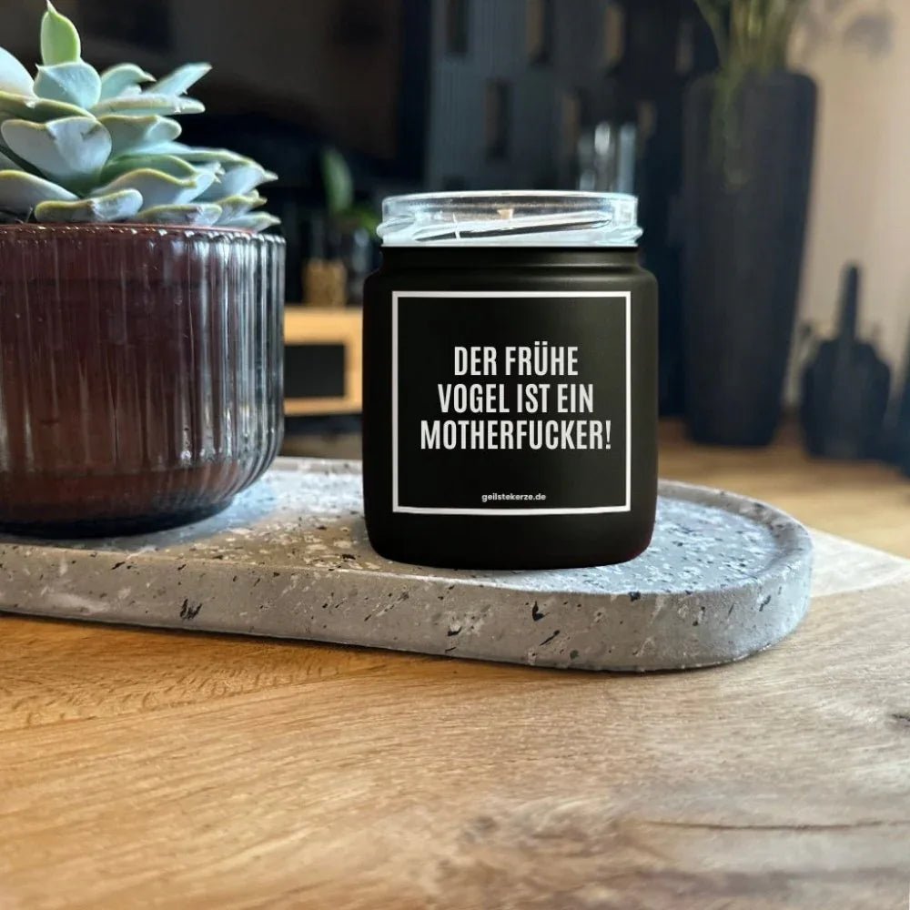 Duftkerze mit Spruch von geilstekerze ist der neue Geschenketrend. Diese witzige Kerze Vegane Bio-Kerze mit Spruch – DER FRÜHE VOGEL IST EIN MOTHERFUCKER! brennt mega lange sagenhafte 80 Stunde, hochwertige ätherische Öle schaffen beste Duftverteilung. Mit 1400 lustigen Sprüchen perfekt zum Verschenken. Handgemacht in Deutschland von geilstekerze.shop -Die beste Duftkerze die du kaufen kannst.