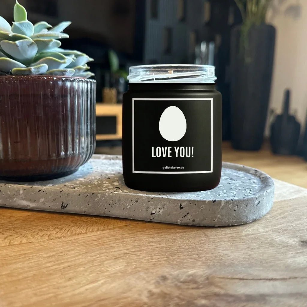Duftkerze mit Spruch von geilstekerze ist der neue Geschenketrend. Diese witzige Kerze Vegane Bio-Kerze mit Spruch – EI LOVE YOU! brennt mega lange sagenhafte 80 Stunde, hochwertige ätherische Öle schaffen beste Duftverteilung. Mit 1400 lustigen Sprüchen perfekt zum Verschenken. Handgemacht in Deutschland von geilstekerze.shop -Die beste Duftkerze die du kaufen kannst.